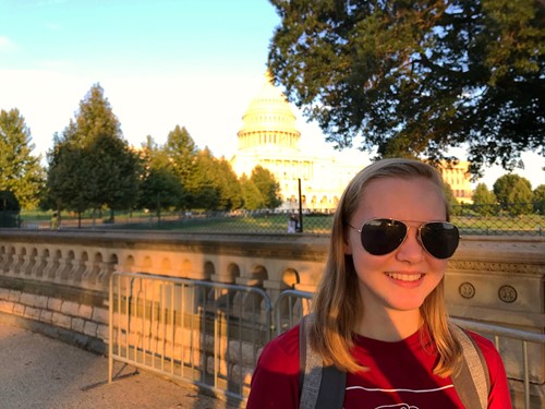 Maeve Hackman with sunglasses in front of U.S. Capitol building