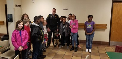 Group of students standing with police officer and K nine