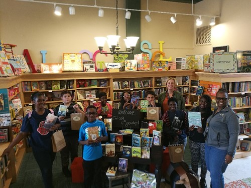 Group of students with books in bookstore
