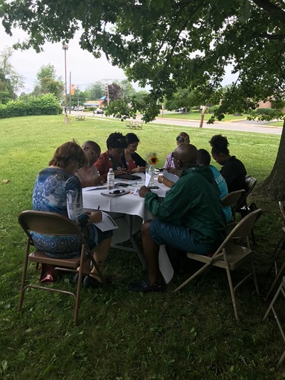 Participants sitting around table in park