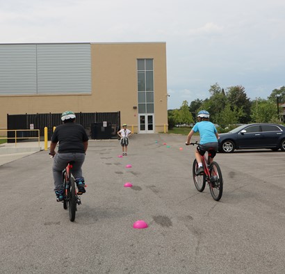 Two bicycle riders in parking lot