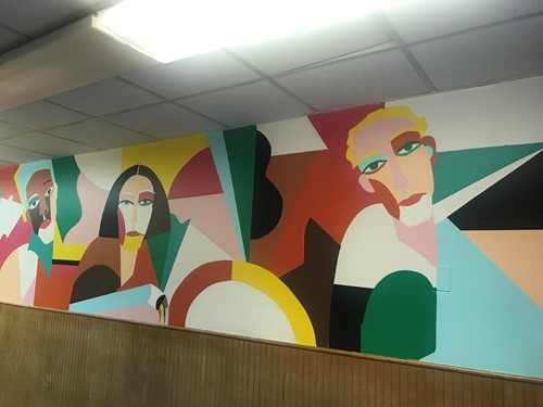 long photo of mural with faces