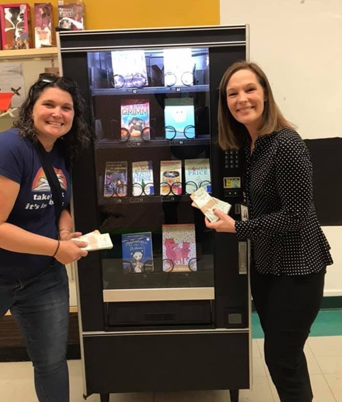 two women with book vending machine