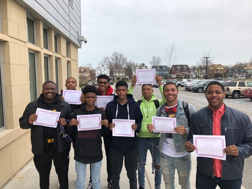 Group of male students with certificates