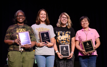 four teachers smiling with plaques