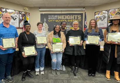 staff members holding certificates