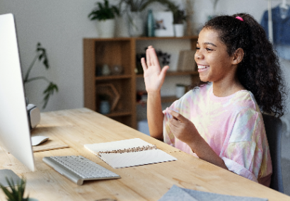 child at table with computer