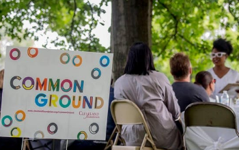 common ground sign and people talking at table outside