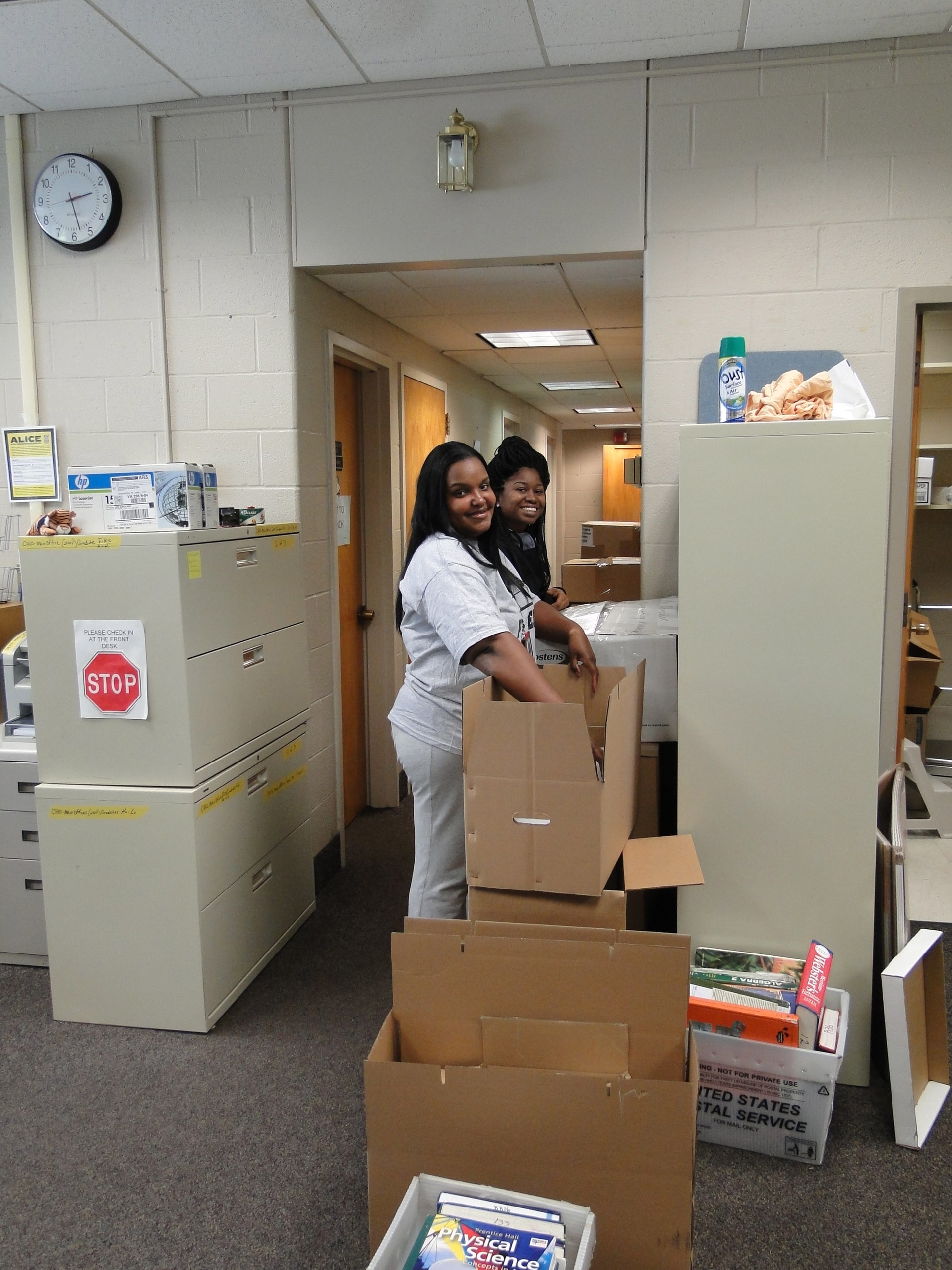 Main office staff Sherelle Rozier and Marissa White (L-R) pack boxes.