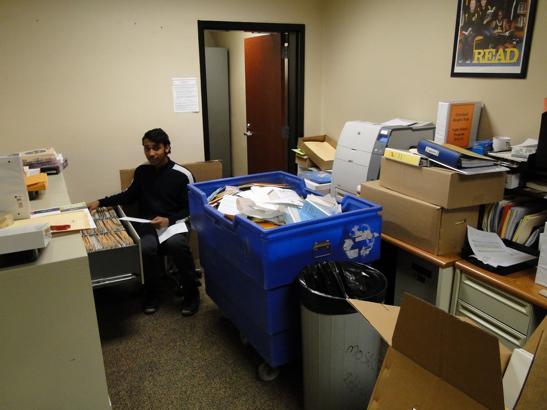 Student volunteer helps recycle outdated files.