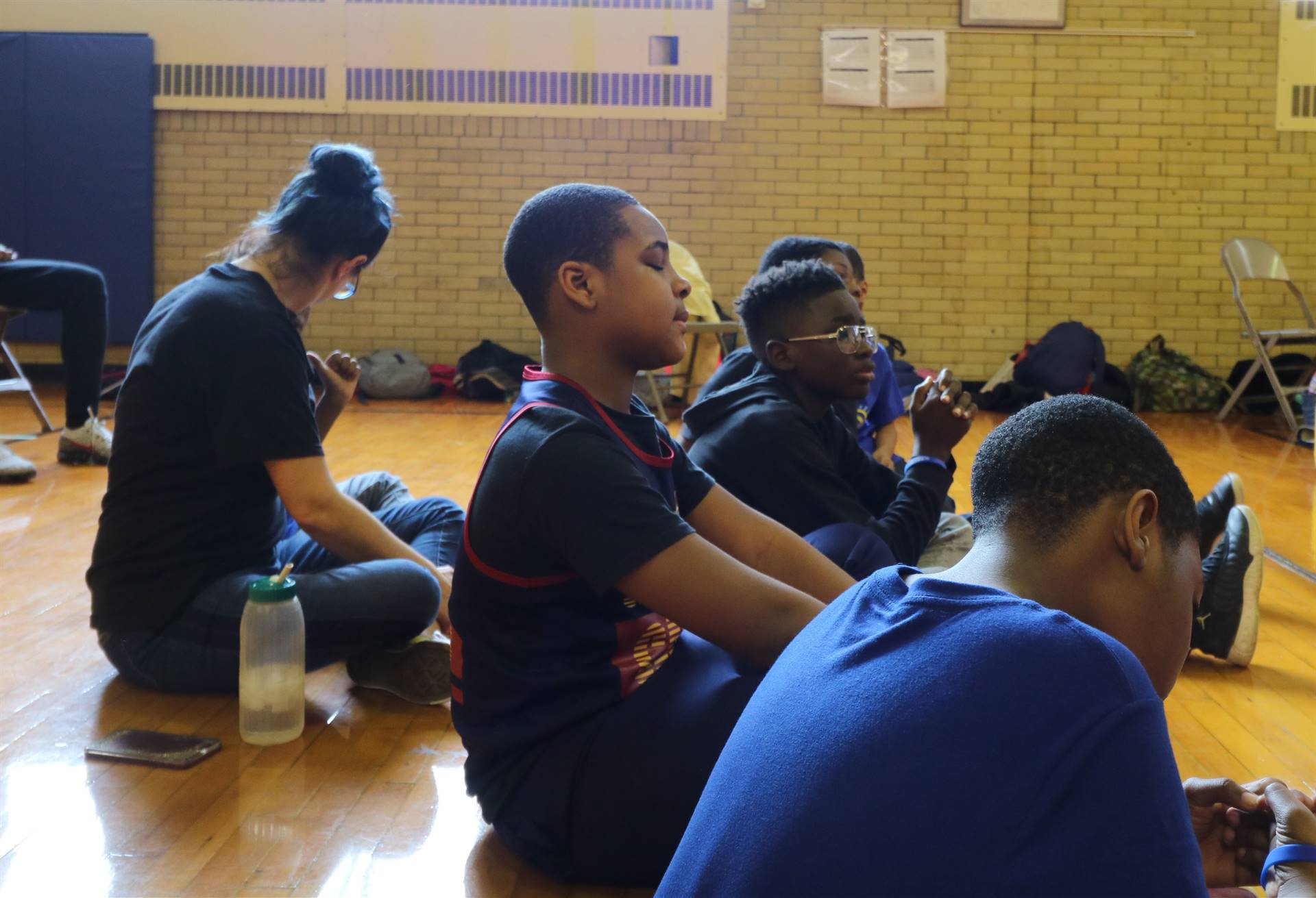 Male student sits with eyes closed meditating