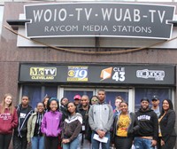 Digital media students with teacher Ms. Booker in front of Channel 19. 
