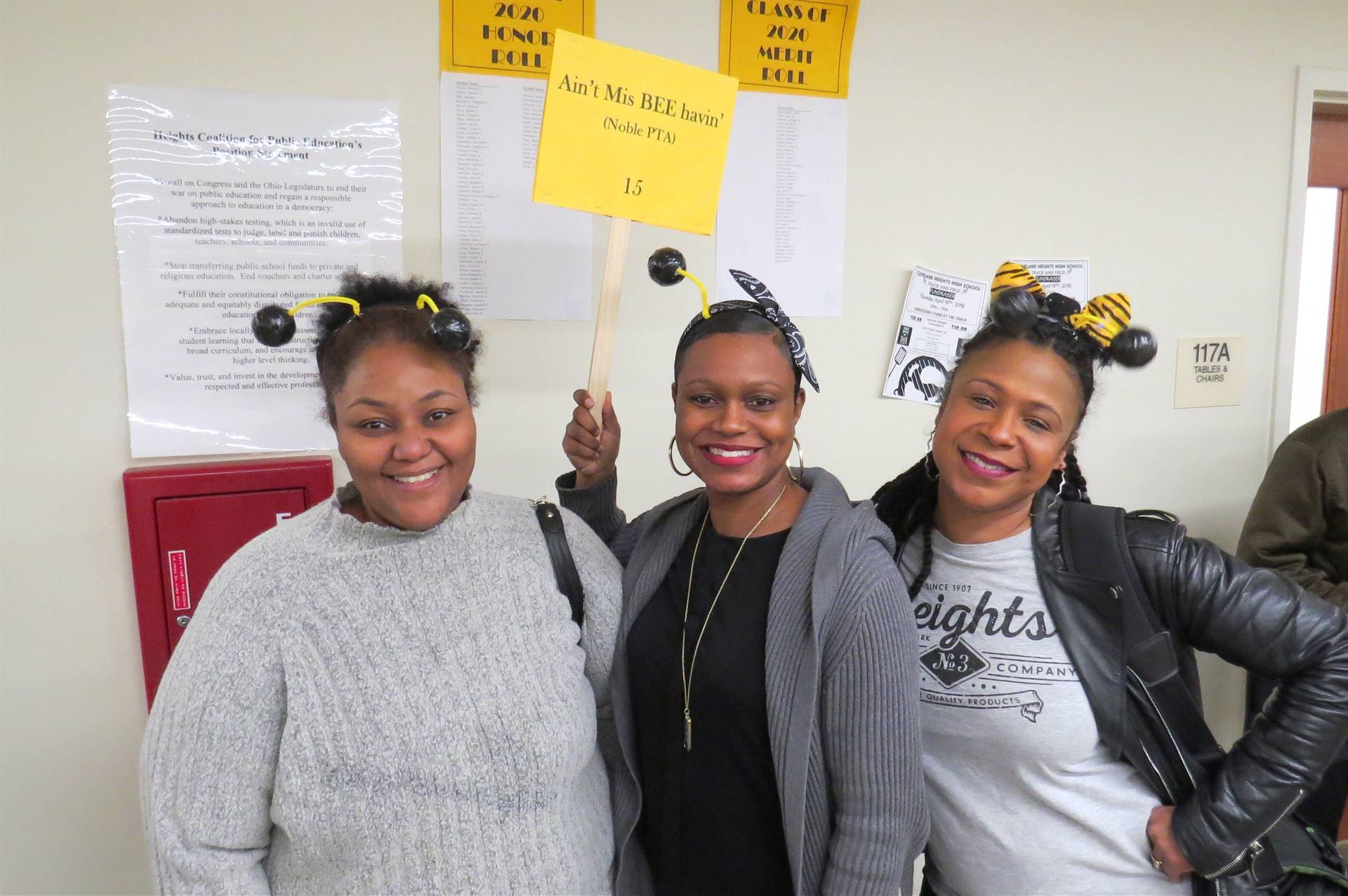 Three females with signs smiling