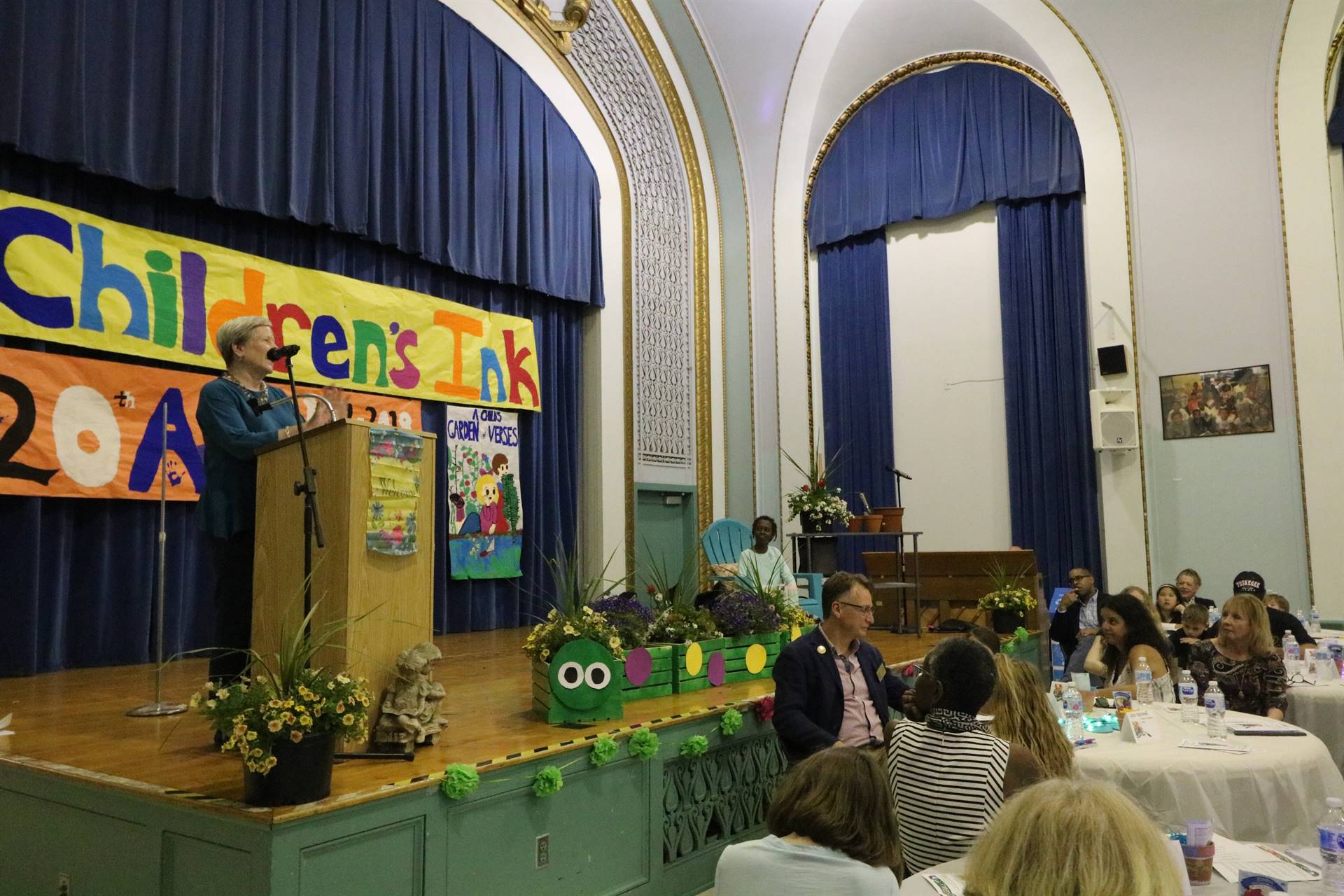 Female reader at podium with student sitting