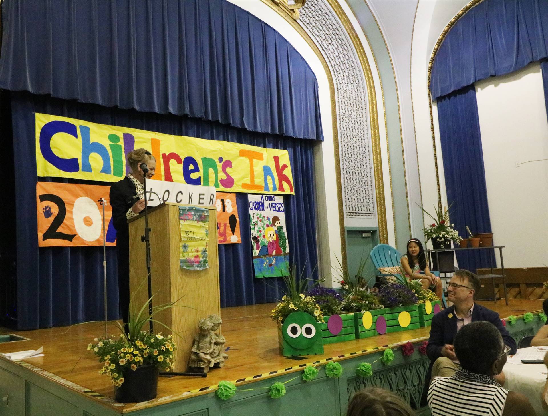 Female reader at podium with student sitting