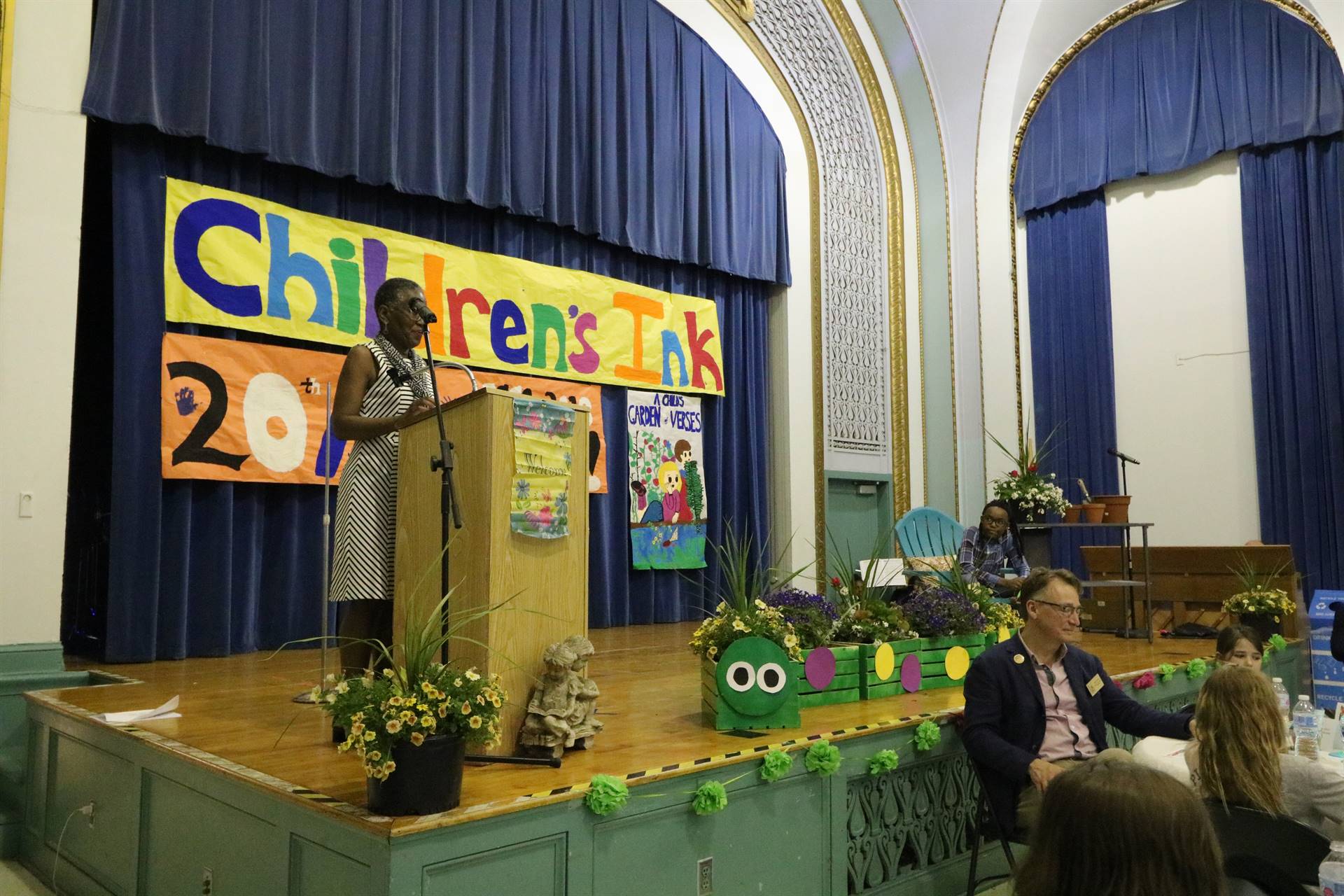 Female reader at podium with student sitting