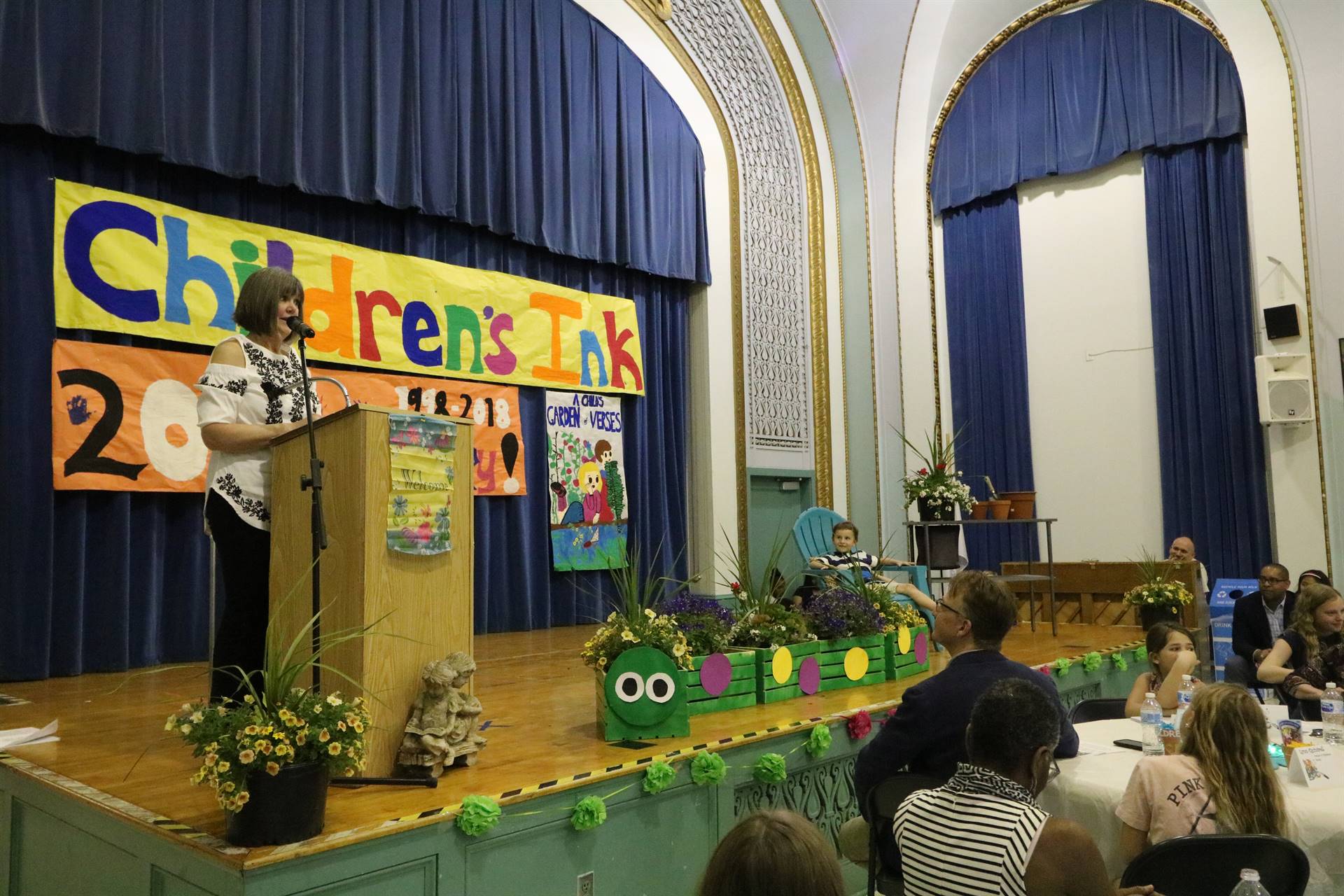 Female reader at podium with student sitting