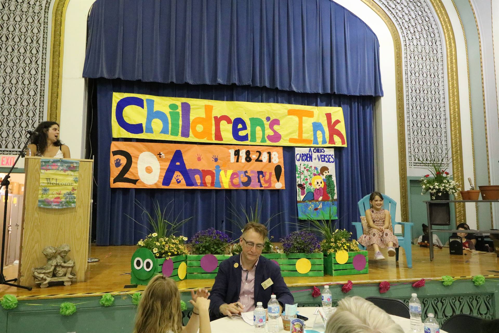 Female reader at podium with student sitting