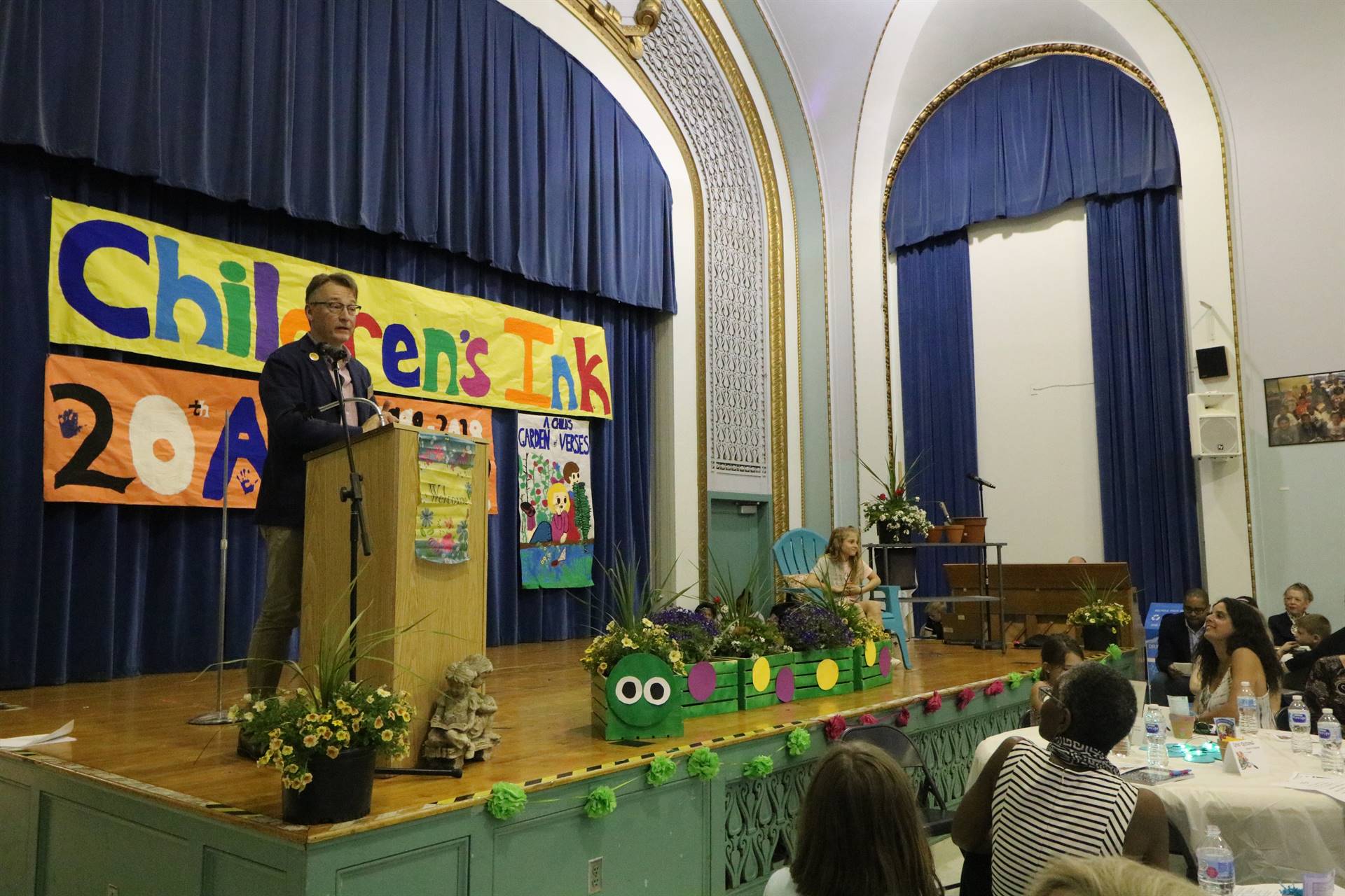 Male reader at podium with student sitting