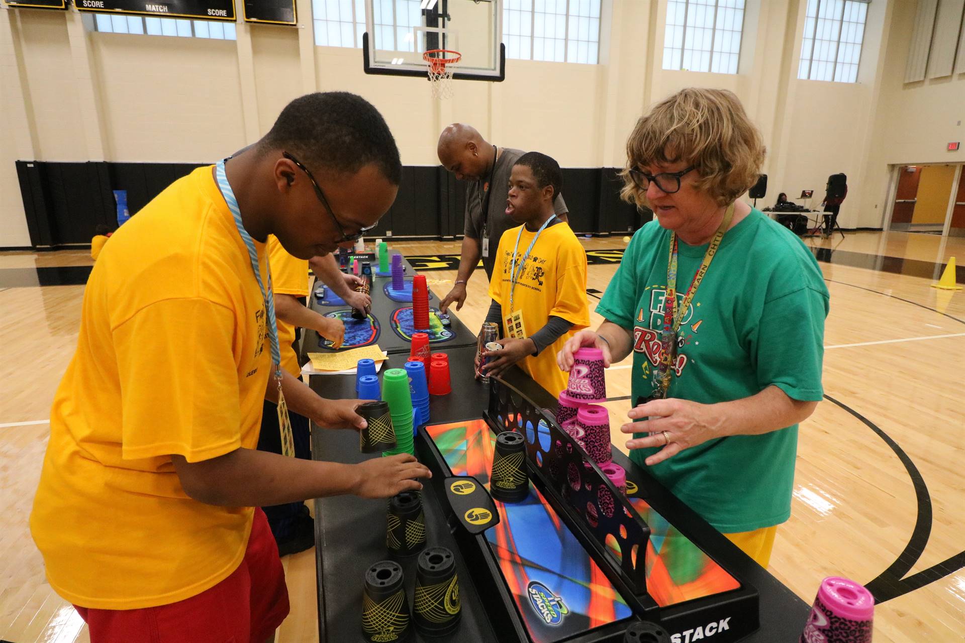 Boy and adult playing cup stacking game at table