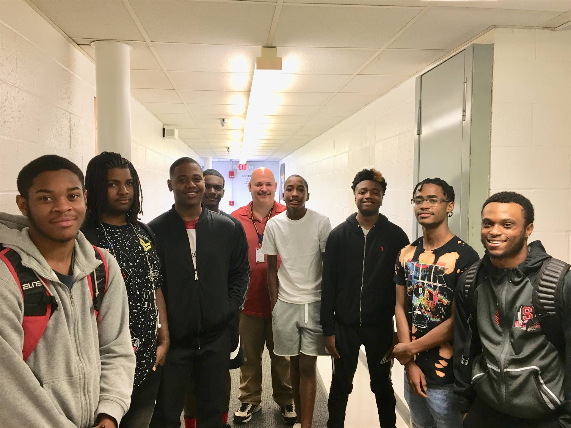 Students and teacher standing in a line smiling