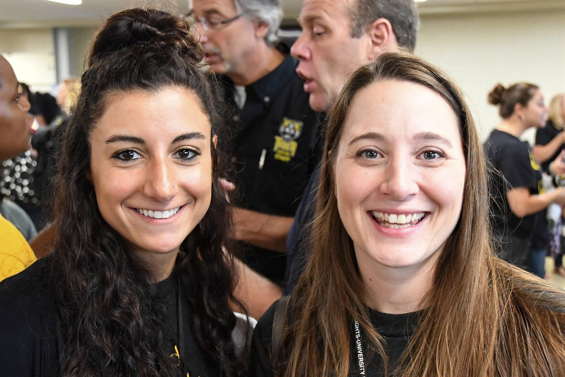 Two staff members smiling