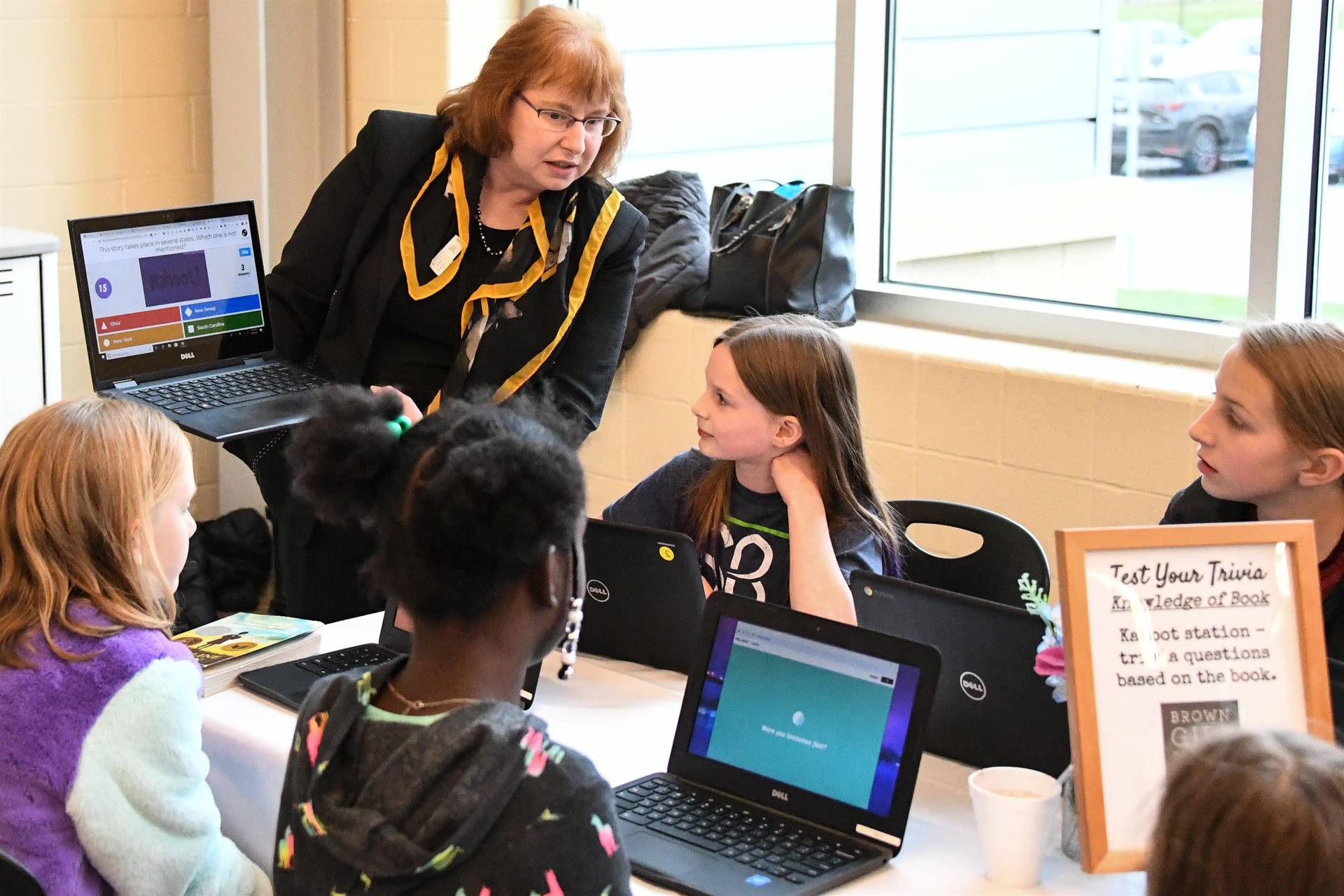 Group of kids and one adult working on computers