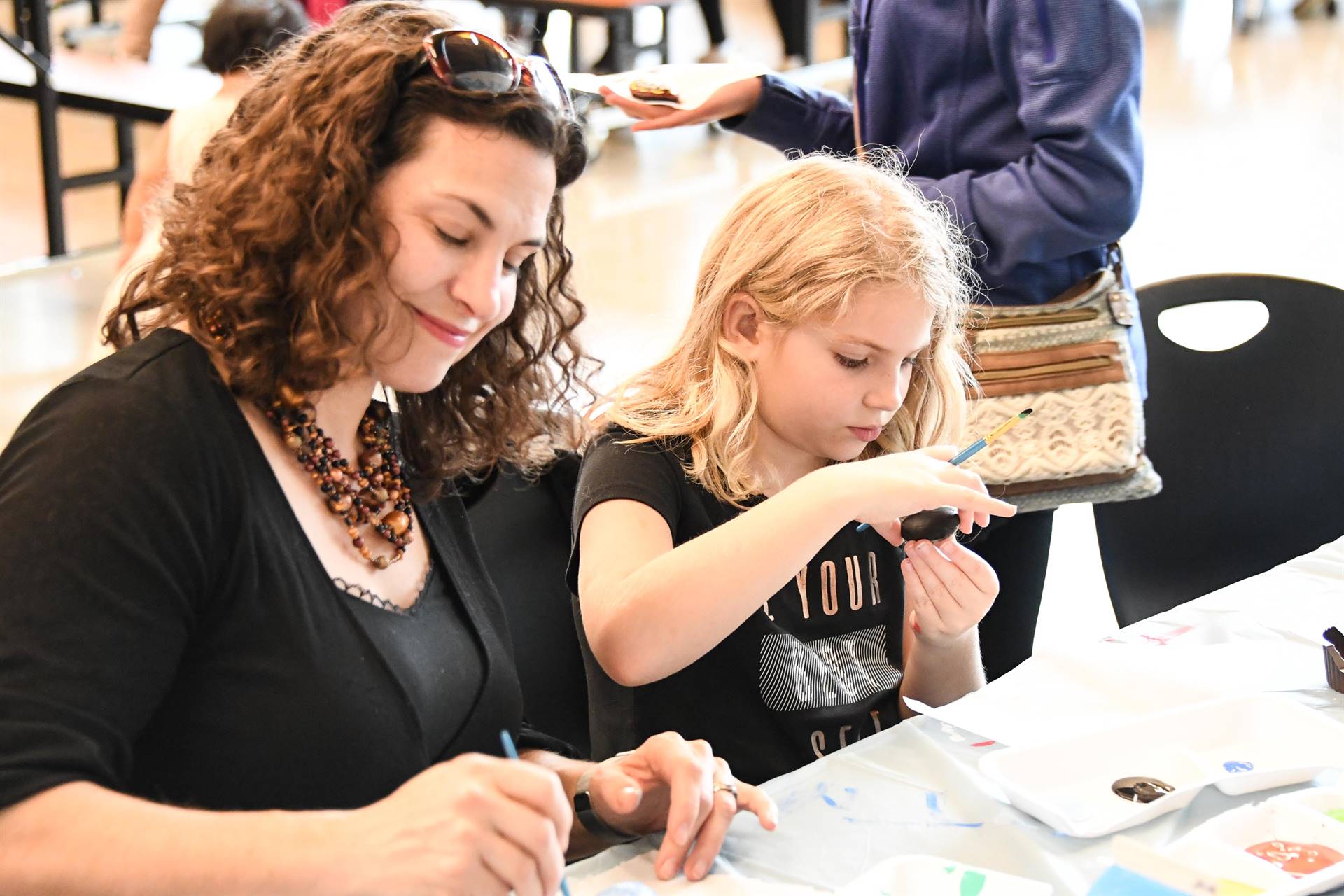 Woman and child painting eggs