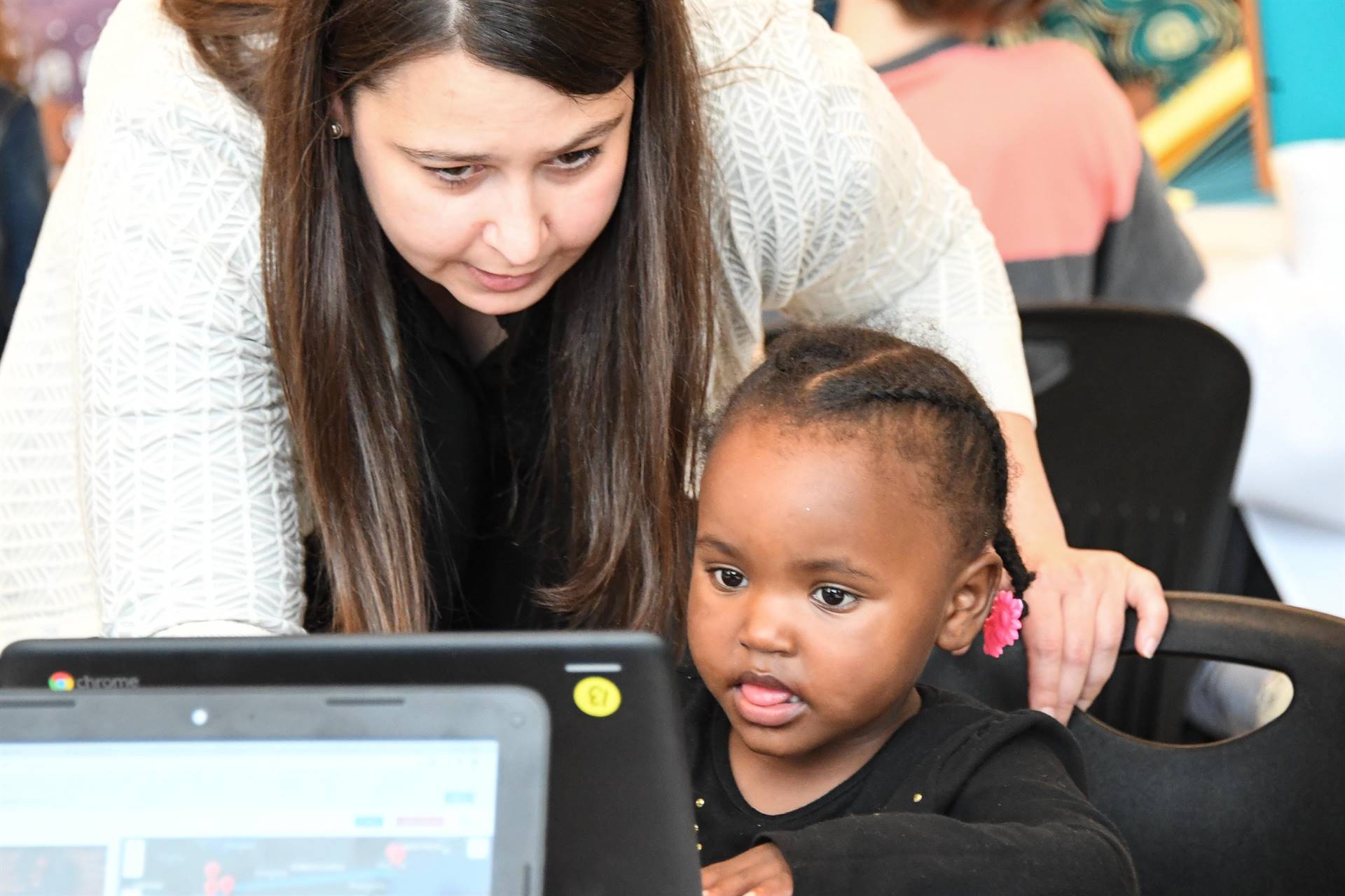 Small child and adult at computer