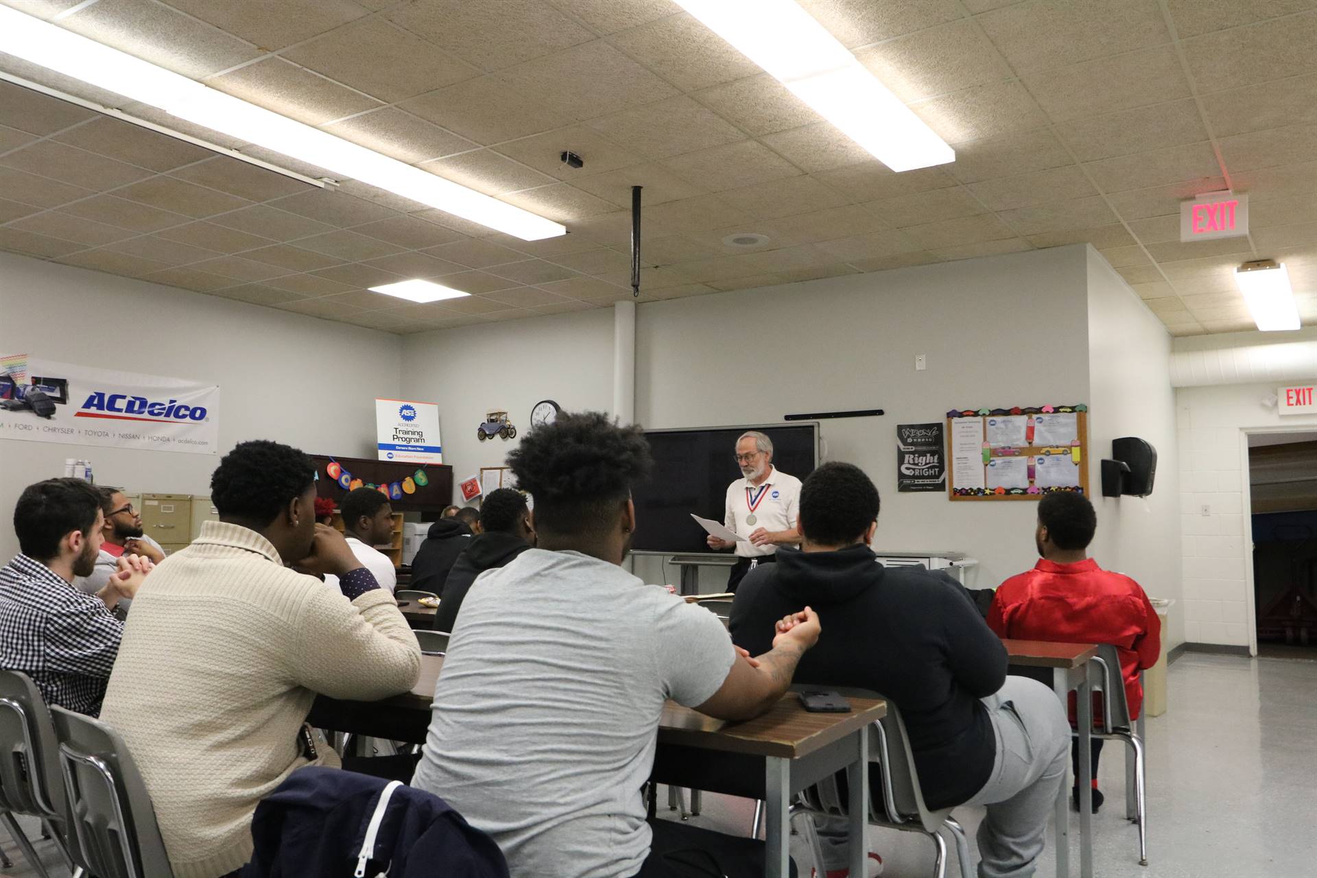 man standing speaking to students