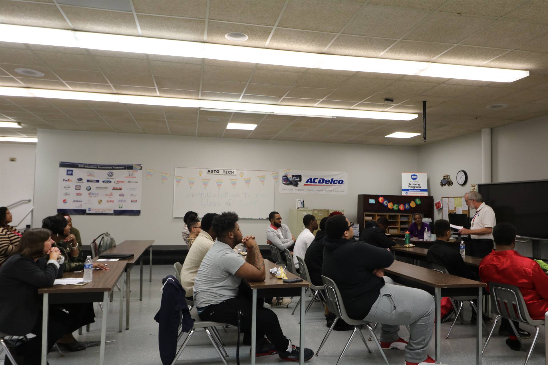 man standing speaking to students