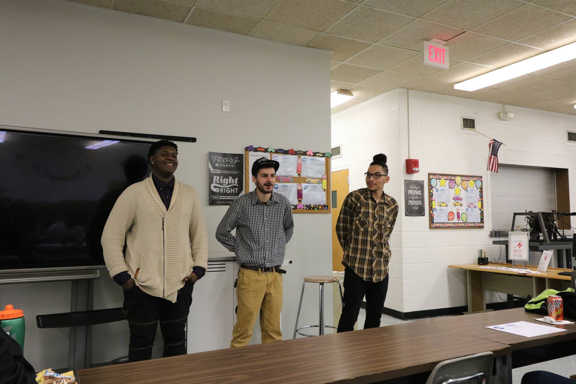 three students standing in front of class