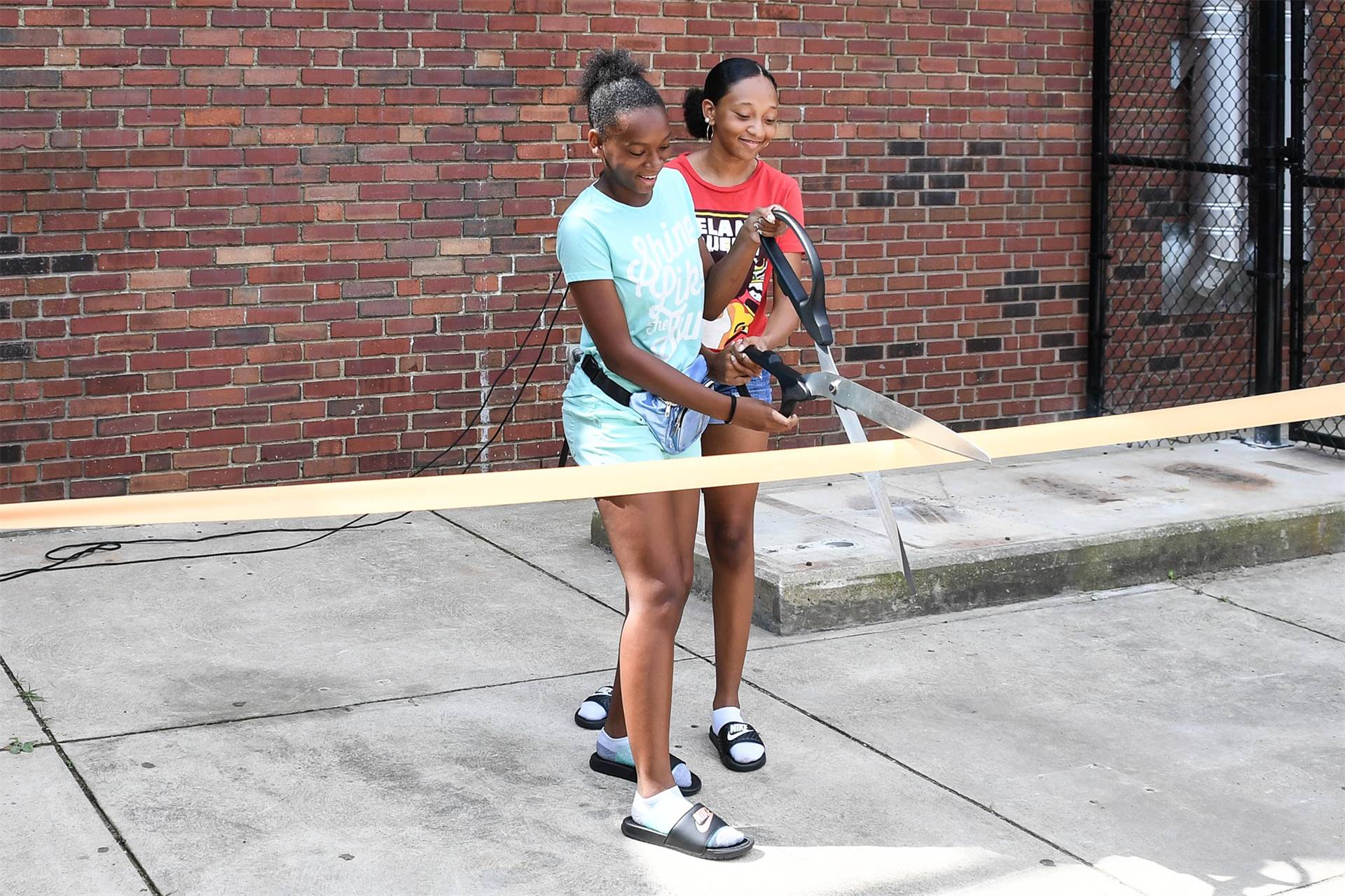 two girls cutting ribbon